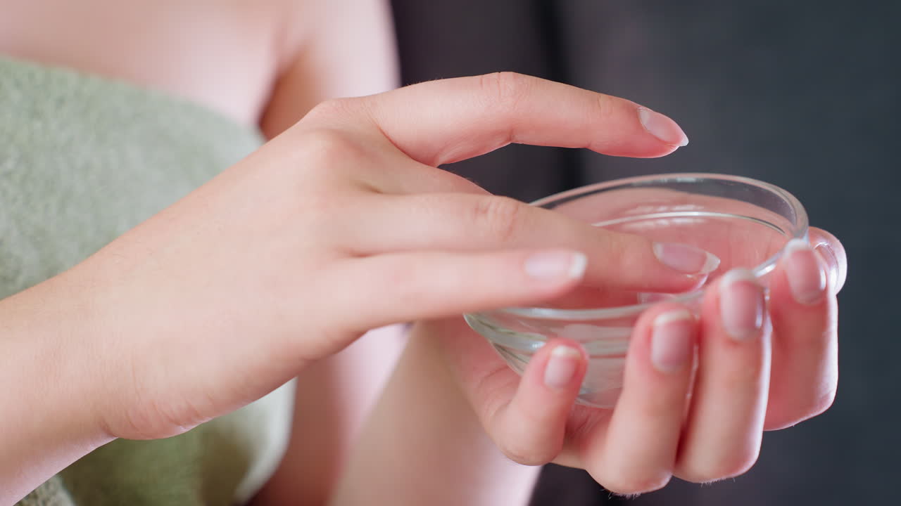 Hand view of lady holding and mixing cream in container, preparing to apply, beauty routine, skincare treatment, moisturizing, facial care, soft skin, hydration, self-care session