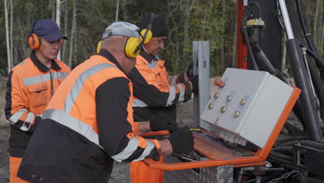 trabajadores de la construcción que reparan maquinaria