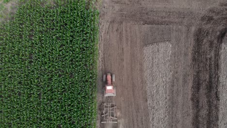 top view of a tractor tilling the soil at the farm field