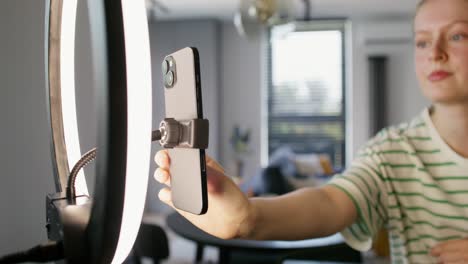 mujer grabando video usando luz de anillo y teléfono inteligente