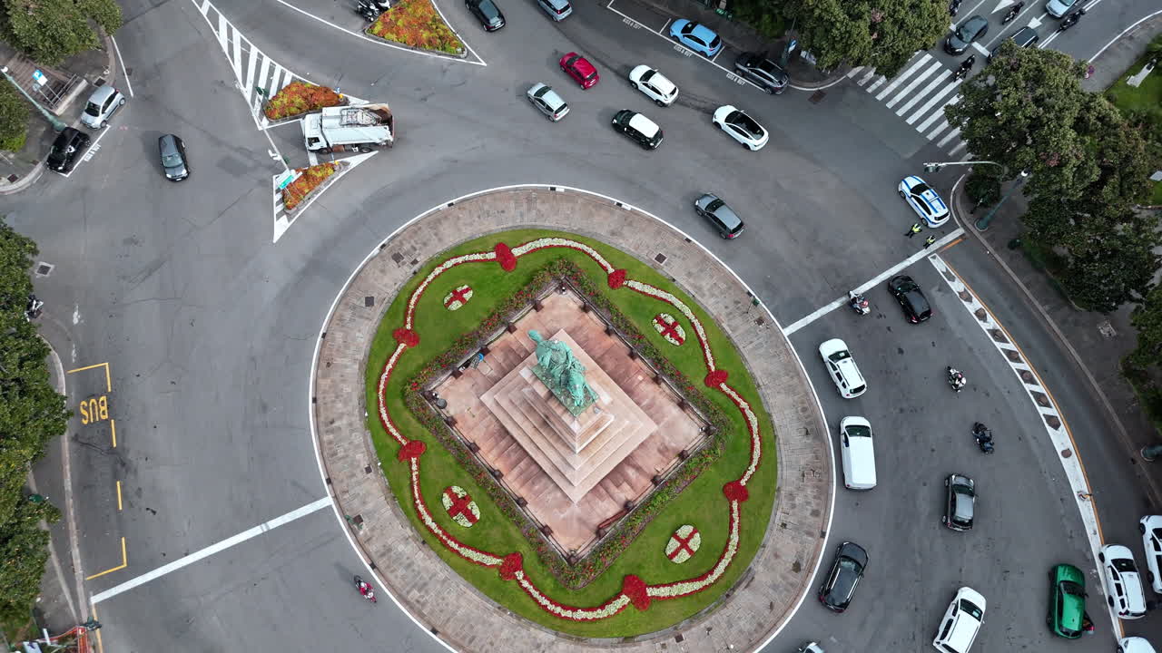Arcing aerial view around Piazza Corvetto with traffic in historic city Genoa