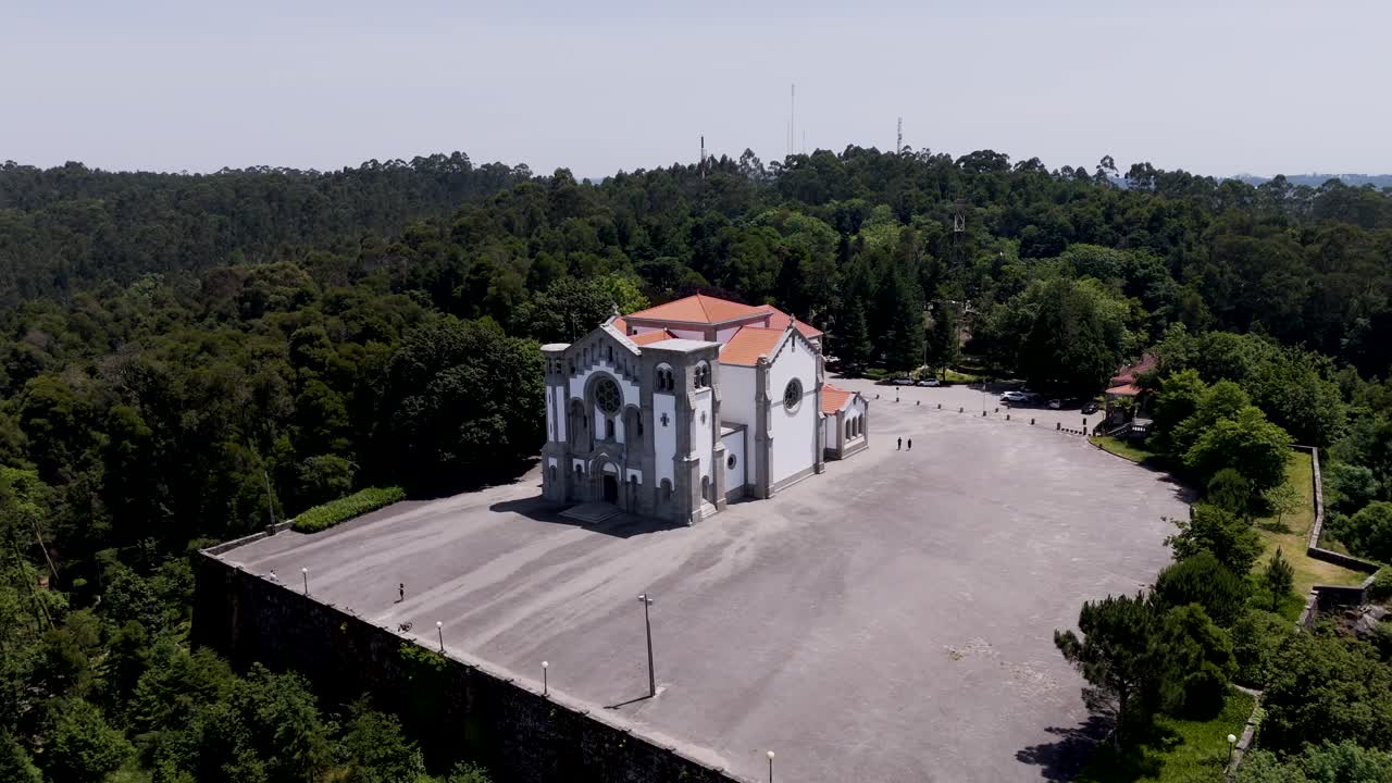 historic sanctuary with red roof stands alone above lush green forest canopy