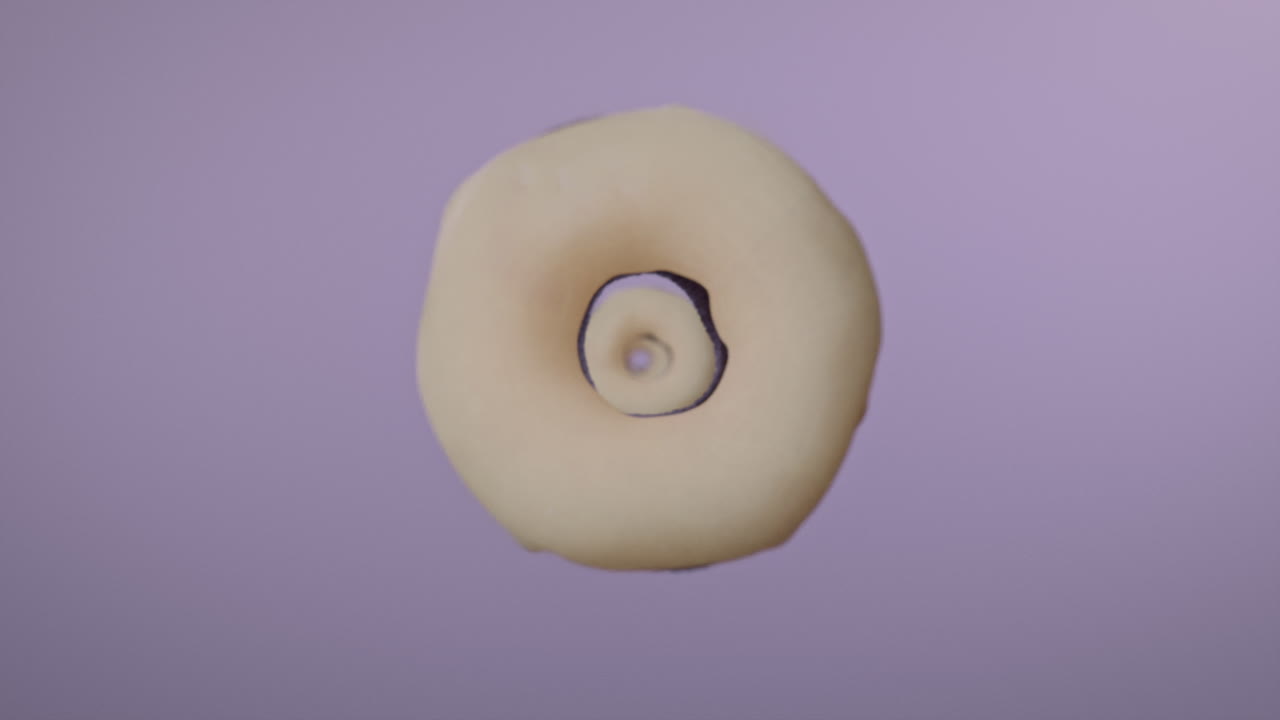White glaze donuts on a light violet background