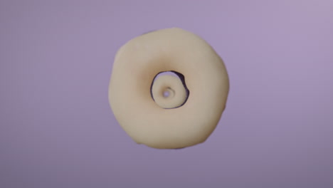 white glaze donuts on a light violet background