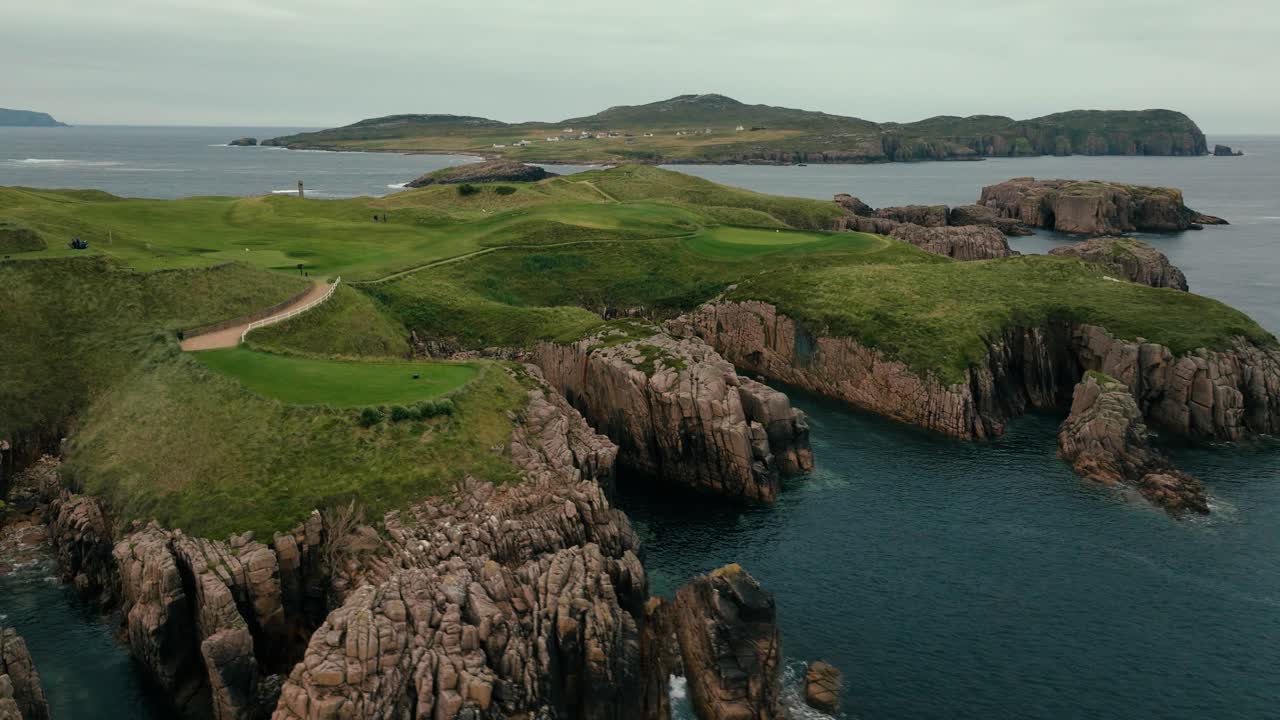потрясающий создание дрона обзорный кадр ирландии связывает поле для гольфа с зелеными и катящимися фейрвеями на прибрежных скалах с видом на океан