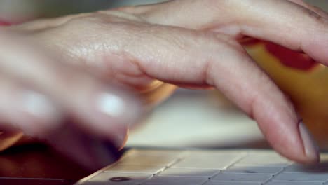las manos de una mujer escribiendo en el teclado de su computadora portátil