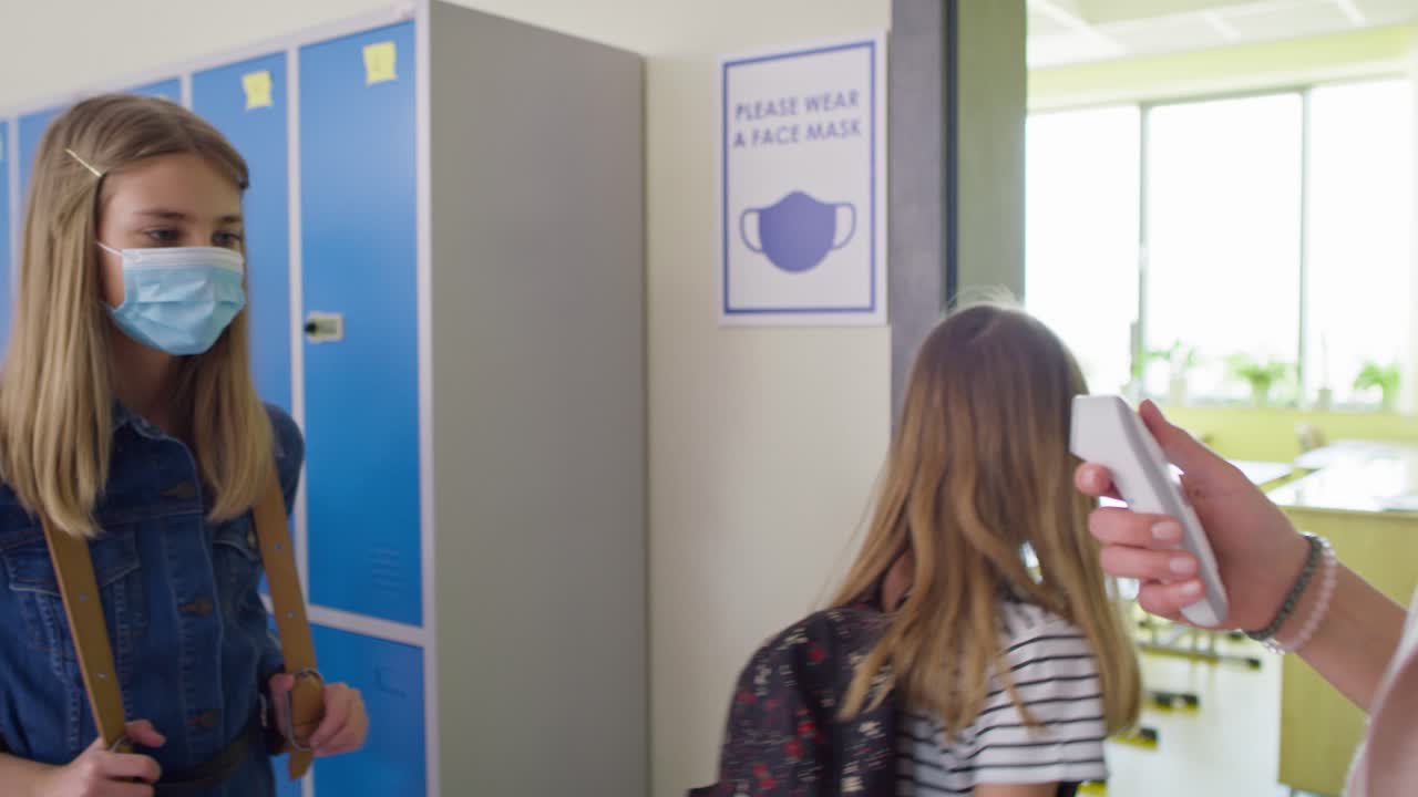 교사가 학교에서 학생들의 체온을 확인하는 영상입니다.