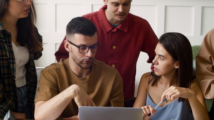 Close Up View Of A Study Group At A Table Standing And Sitting At Home