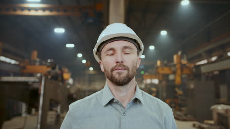 portrait of industrial engineer in safety helmet at work in factory