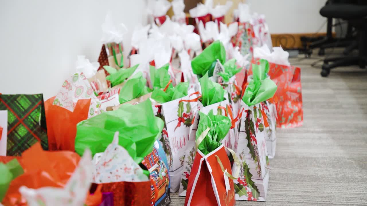 4k larga fila de navidad vacaciones festivas cama de papel víspera de vacaciones regalos envueltos y sentados en una fila en un edificio de oficinas corporativas para santa secreto