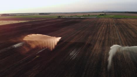 watering plants with a sprinkler on a dry field in europe