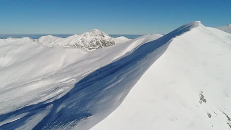 Luftaufnahme,-Die-über-Einen-Schneebedeckten-Bergkamm-Fliegt,-Der-Die-Landschaftliche-Schönheit-Der-Größeren-Kantabrischen-Bergkette-In-Nordspanien-Offenbart