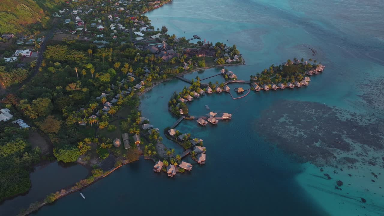 Bungalow villas morning islands Cooks Opunohu Bay Moorea French Polynesia aerial drone Mount Mauaroa Tohivea Rotui clouds lagoon coral reef vibrant green blue Pacific Ocean circle right birdseye view
