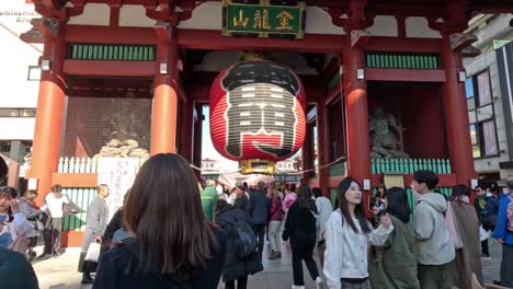 tourists and locals visiting a traditional temple gate.