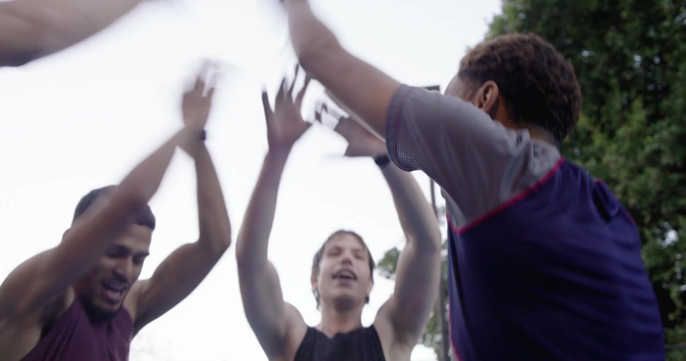 Diverse male pals huddling leader giving pep stacking breaking and playing basketball on blue court