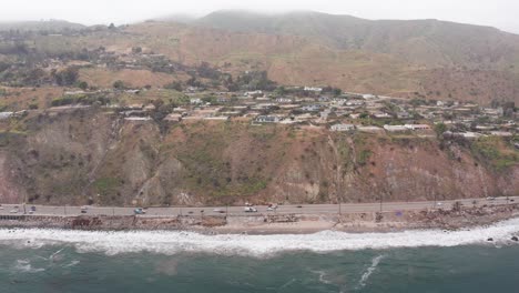 wide dolly aerial shot of burned beachfront homes along pacific coast highway in the aftermath of the palisades wildfire in malibu, california. 4k
