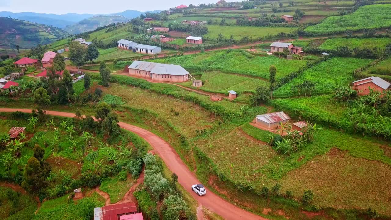 vehículo viajando a través del paisaje pintoresco en uganda, áfrica - toma aérea de dron