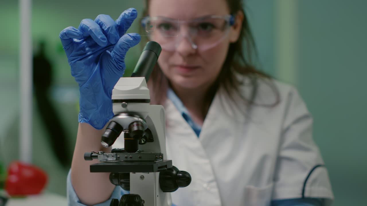 Closeup of scientist woman looking at test sample of lea