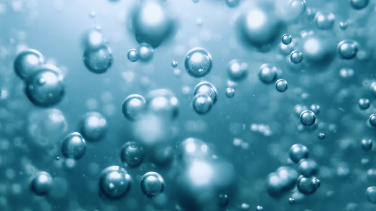 Many water bubbles in blue water close up, abstract water wave with bubbles in slow motion.