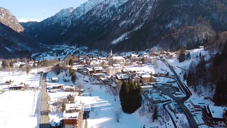 cinematic drone shot of city in during winter revealing big mountain covered in snow