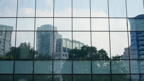 Reflection-of-trees-and-business-buildings-in-the-mirror-walls-of-other-buildings-downtown-financial-area-of-a-big-city