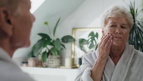 Senior-caucasian-woman-in-the-bathroom-having-a-strong-toothache