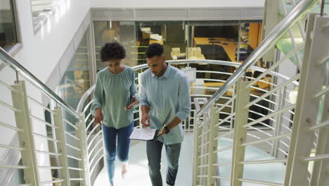 video of diverse businessman and businesswoman talking and walking upstairs