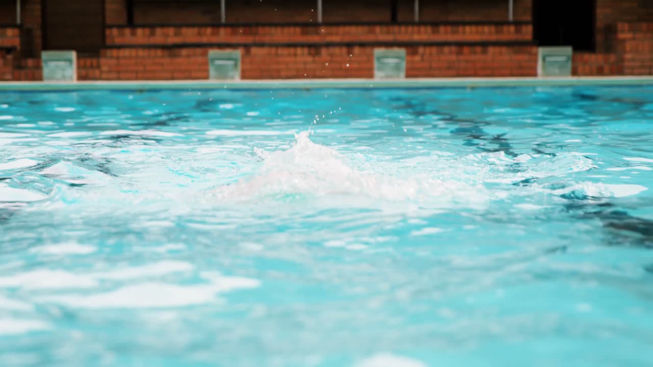 Ældre mand, der svømmer i poolen