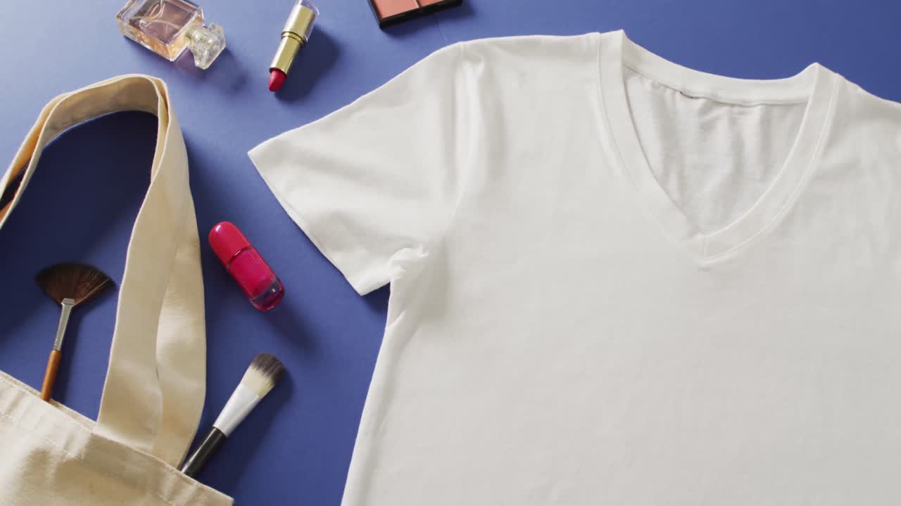 video de primer plano de camiseta blanca, bolso y maquillaje sobre fondo púrpura