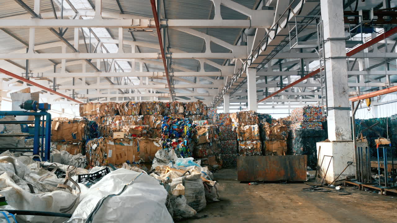 View of interior of a waste sorting plant. Cubes of compressed garbage, special tools