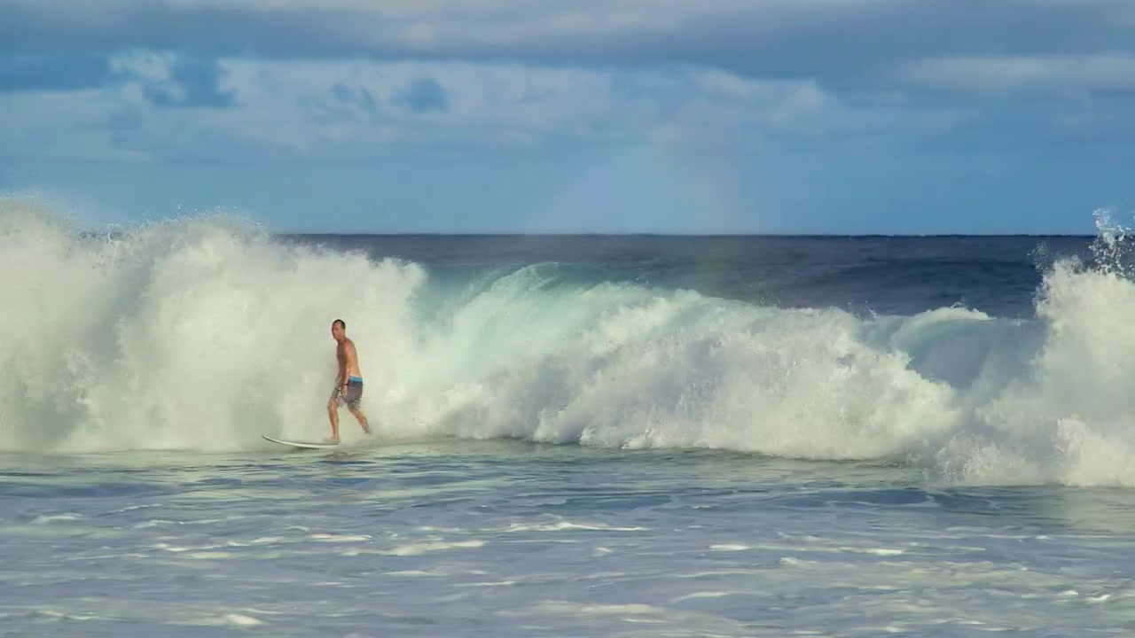 Surfer rider på en bølge og falder, mens bølgen bryder