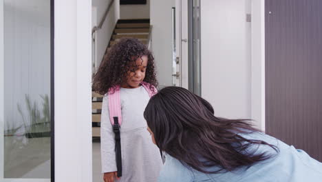 mother giving daughter high five as she leaves for school