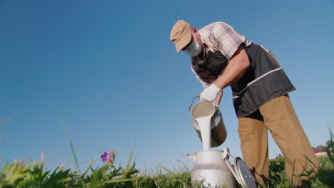 a man in a protective mask and gloves pours milk into a can 1