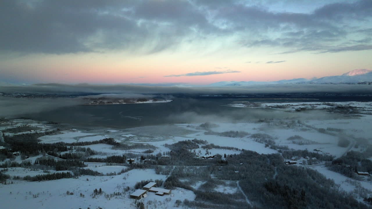vuelo de drones sobre el paisaje cubierto de nieve helada en el círculo polar ártico al atardecer