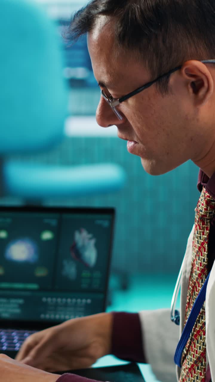 Male Doctor Examining X-ray Scan and Using Laptop in Medical Office
