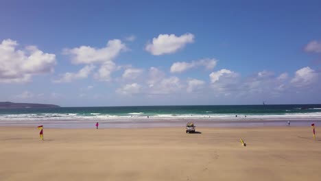 Aerial-View-Of-Flags-In-Godrevy-Beach-With-Seascape-Views-In-Cornwall,-UK