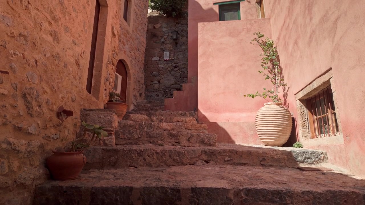 Scalini rustici in pietra di un vicolo mediterraneo con suggestivi colori arancioni.