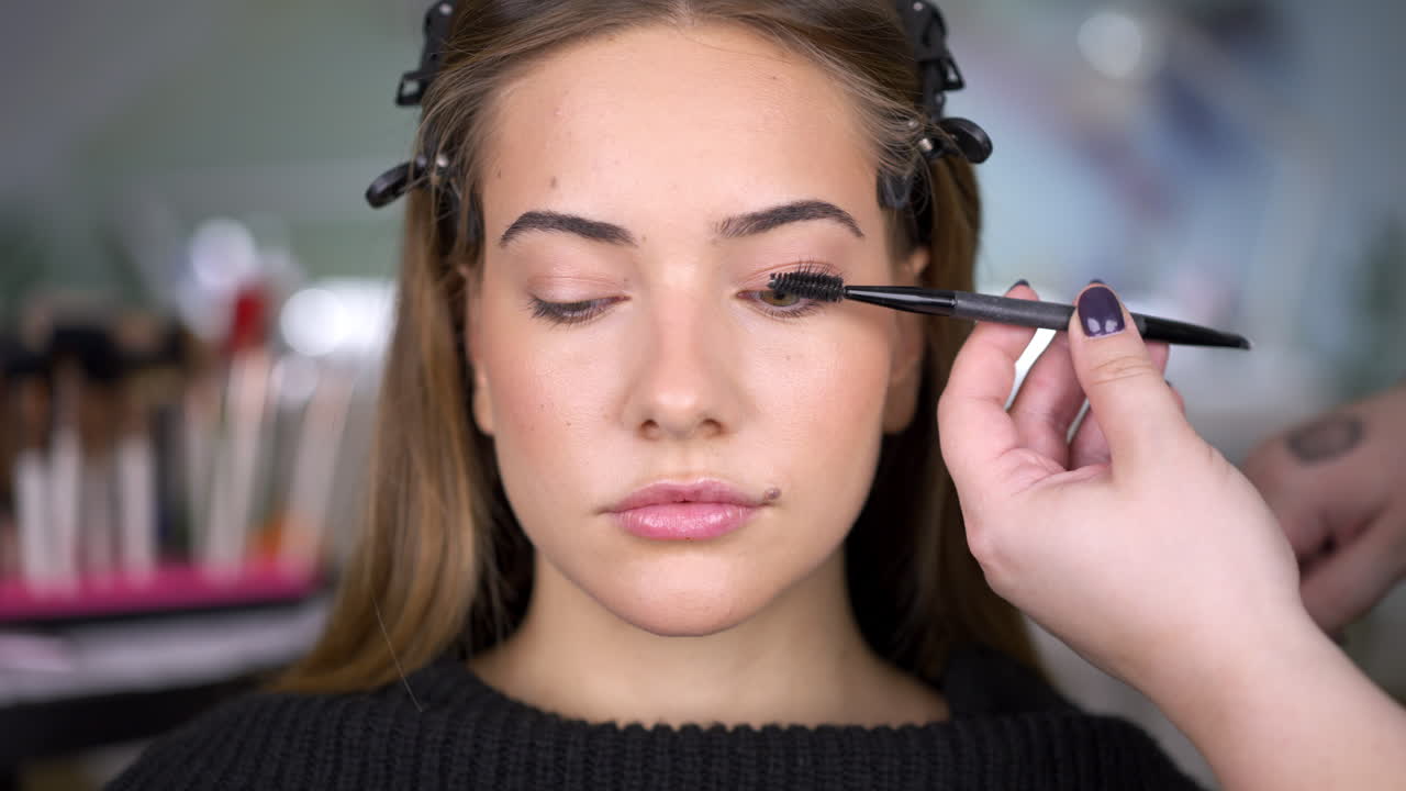 Close-up of a woman having mascara applied to her eyelashes