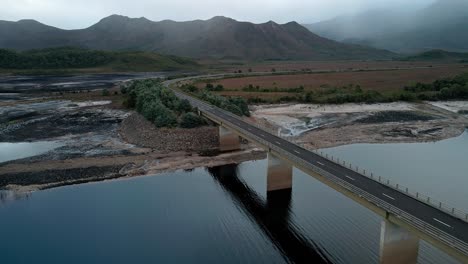 Aerial-drone-backward-moving-shot-over-Bradshaw-Bridge-that-spans-over-artificial-Lake-Burbury-along-the-western-coast-of-Tasmania-during-evening-time