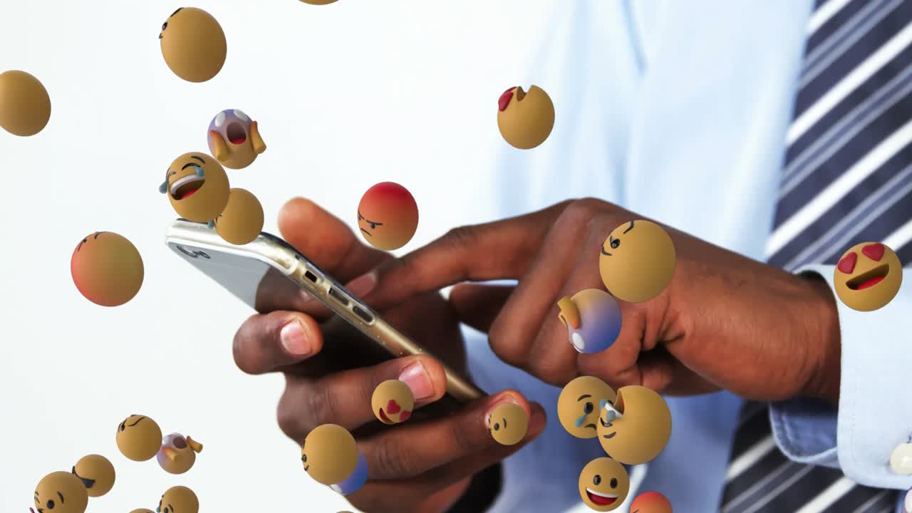 animación de iconos emoji sobre un hombre de negocios afroamericano usando un teléfono inteligente.