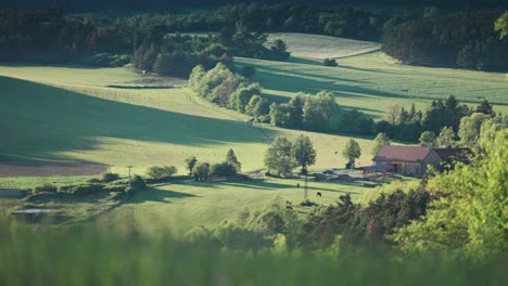 Una-Granja-Tranquila-Y-Aislada-Situada-En-Un-Exuberante-Valle-Verde,-Rodeada-De-Colinas-Y-Bosques.