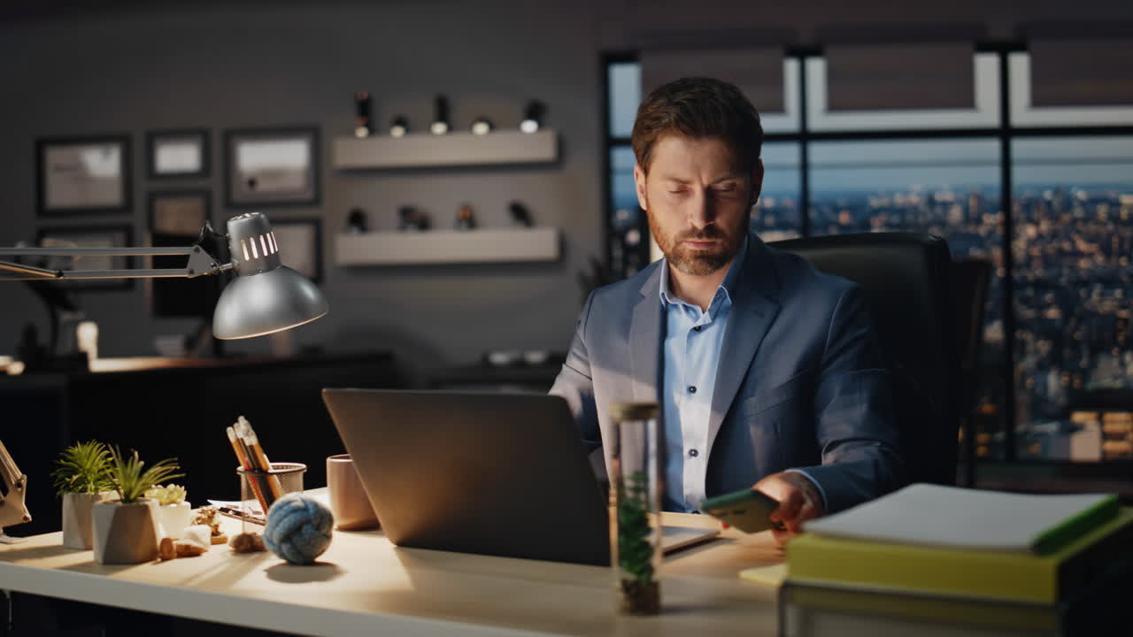 Serious man receiving cellphone message in evening workplace closeup. Guy work