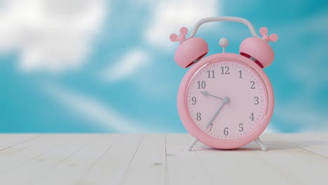 reloj rosado en una mesa de madera y un fondo de cielo brillante.