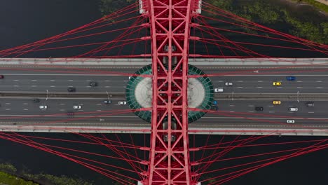 Vista-De-Arriba-Hacia-Abajo-De-La-Escena-Estática-En-Cámara-Lenta-Aérea-Del-Automóvil-En-El-Puente-De-La-Autopista-Roja-Sobre-El-Río,-Moscú,-Rusia