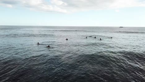 AERIAL-4K-Surfers-Floating-In-Water-Awaiting-Waves,-Lombok-Indonesia