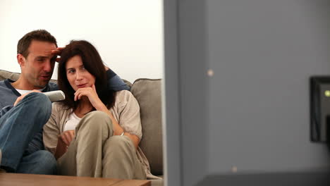 una pareja viendo la televisión.