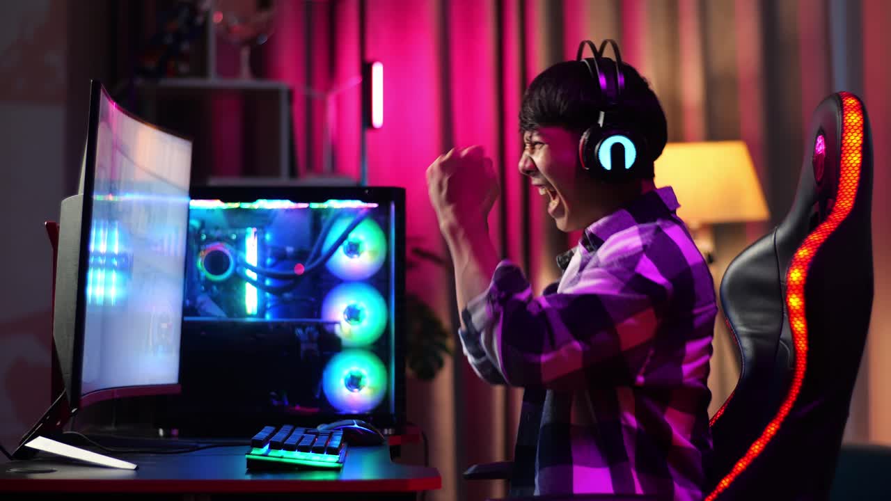 Gamer adolescente asiatico entusiasta festeggia la vittoria mentre gioca a un videogioco al computer