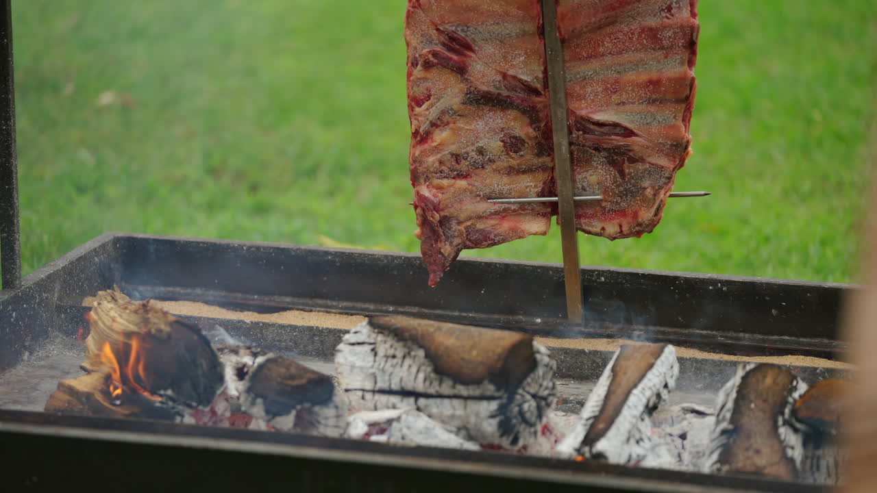 Argentinian barbecue preparation with flames and grilled Ribs, authentic food tradition and rural lifestyle