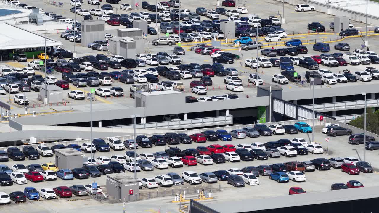 Aerial footage of a bustling parking lot at Pacific Fair shopping center, showcasing numerous parked cars under bright daylight