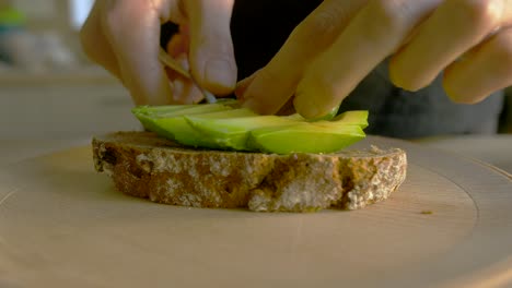 toma en cámara lenta de una mujer blanca haciendo tostadas de aguacate